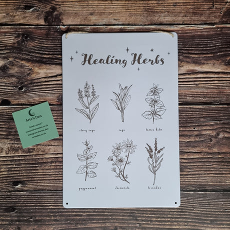 A "Healing Herbs" tin sign with pictures of herbs and their names on a wooden background