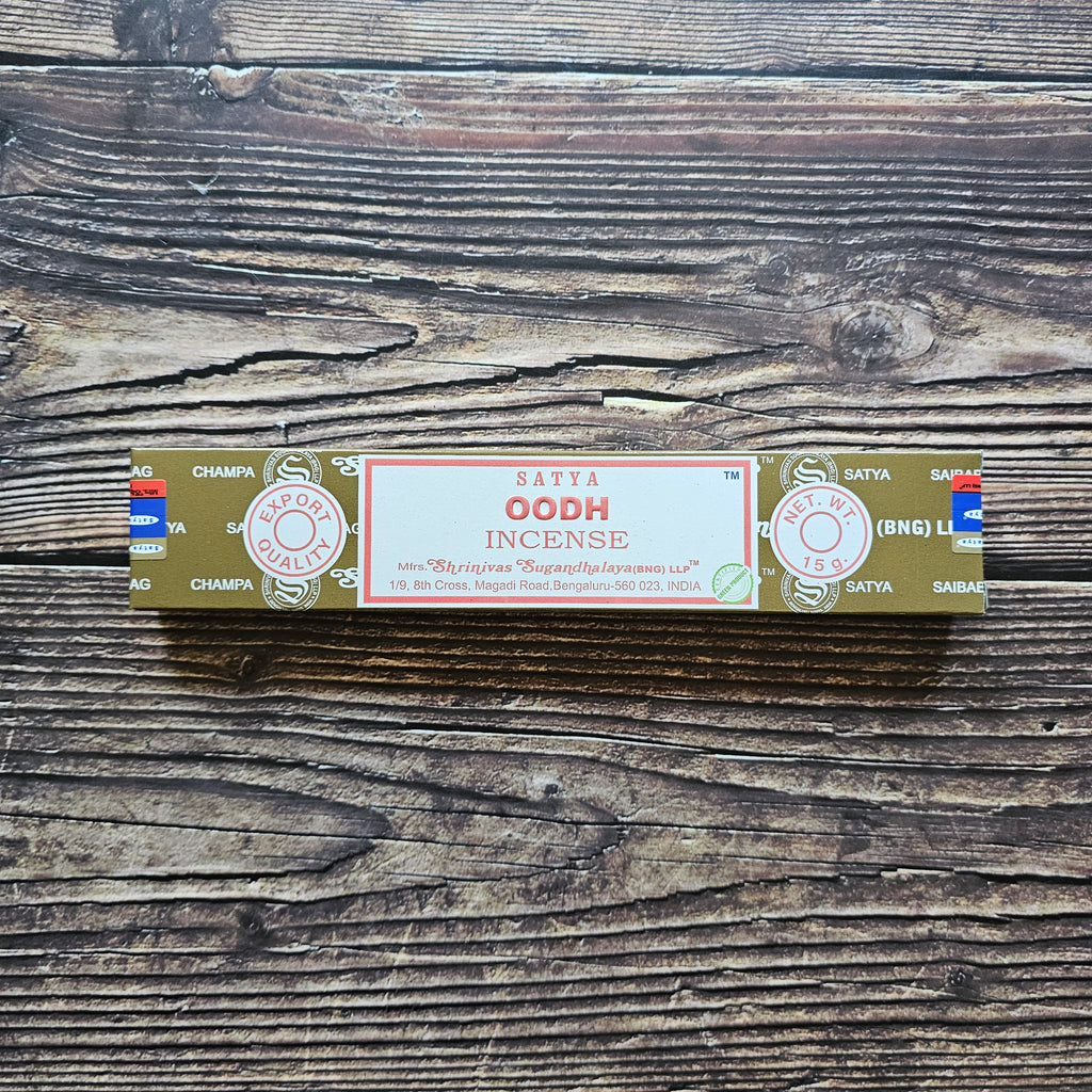 A pack of Satya incense sticks with the label 'OODH' displayed on the packaging. Laid on a wooden background. 