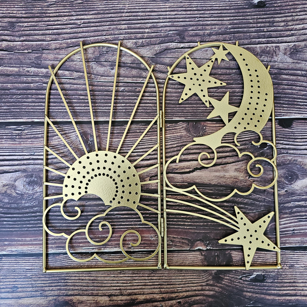 A celestial inspired jewellery stand with sun, moon and star designs on a wooden background.