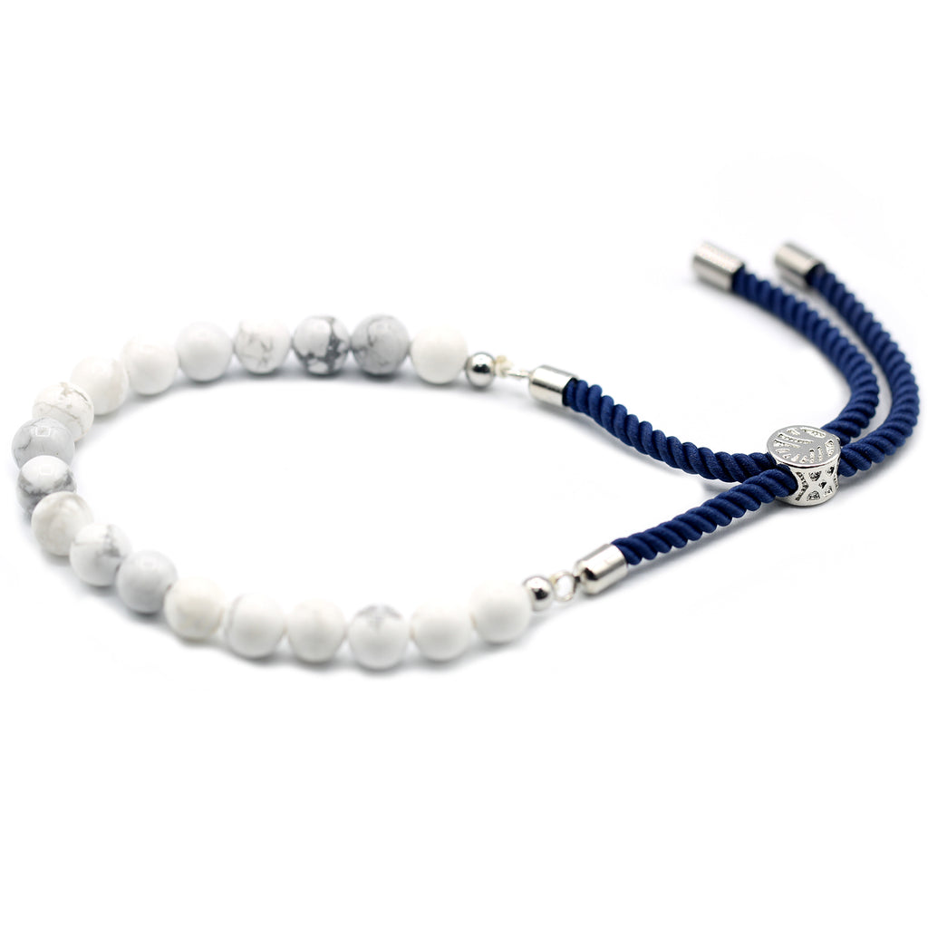 A silver-plated bracelet with navy string detailing and white howlite beads, displayed on a white surface.