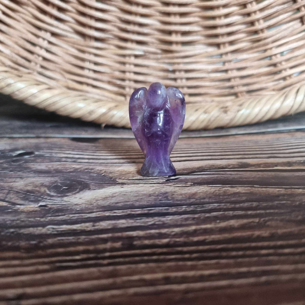 A purple crystal angel on a wooden backdrop 