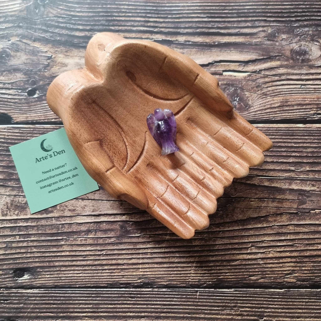 A purple crystal angel on a wooden backdrop 