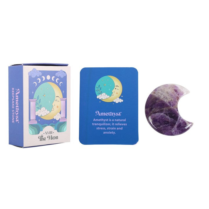 An amethyst crystal moon keepsake stone beside its packaging box, which has 'The Moon' tarot card imagery.