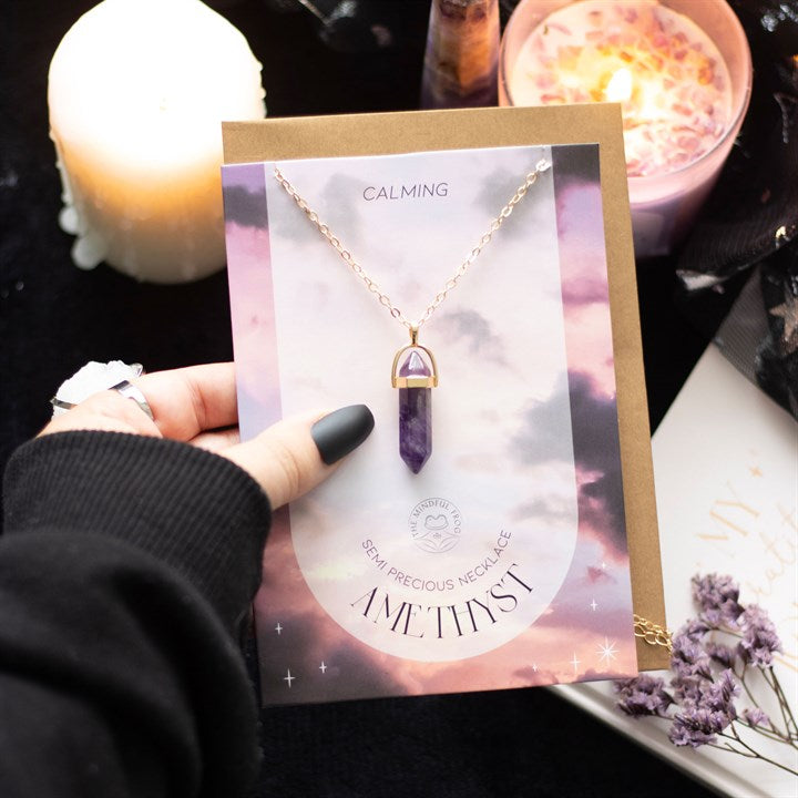 A hand holding an Amethyst Necklace card. 