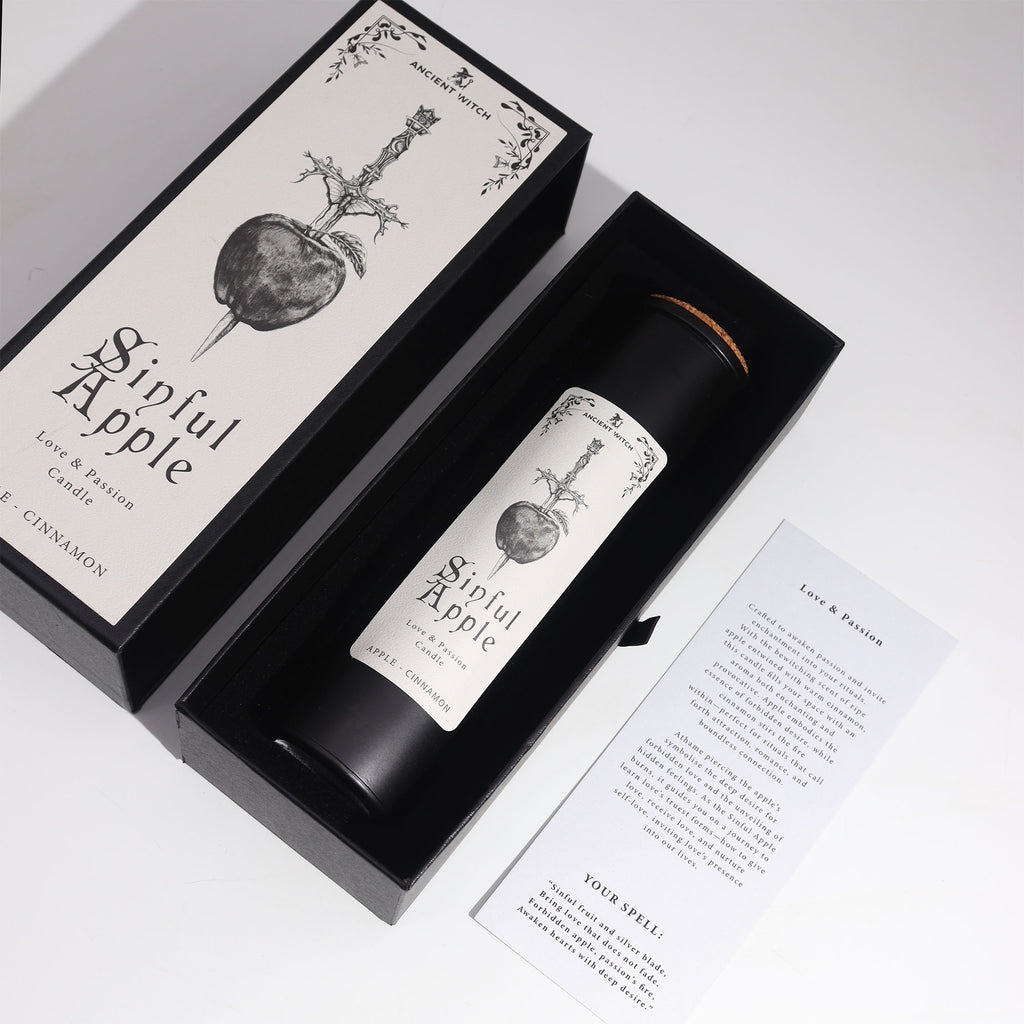 Candle labeled 'Sinful Apple' in a black box with decorative design on a white background