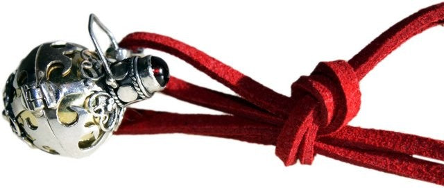 A silver angel bell necklace with a red cord and silver detailing on the necklace and bell.