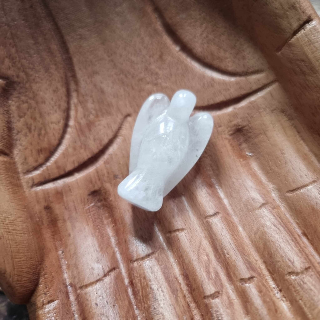 A white crystal angel on a wooden backdrop 