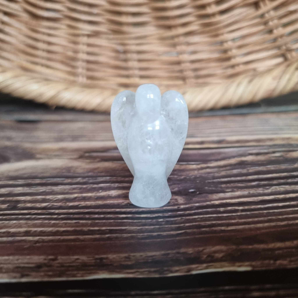 A white crystal angel on a wooden backdrop 