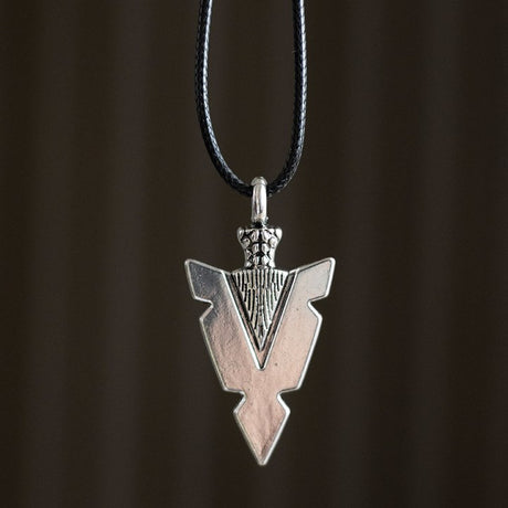 Silver arrow pendant on a dark background