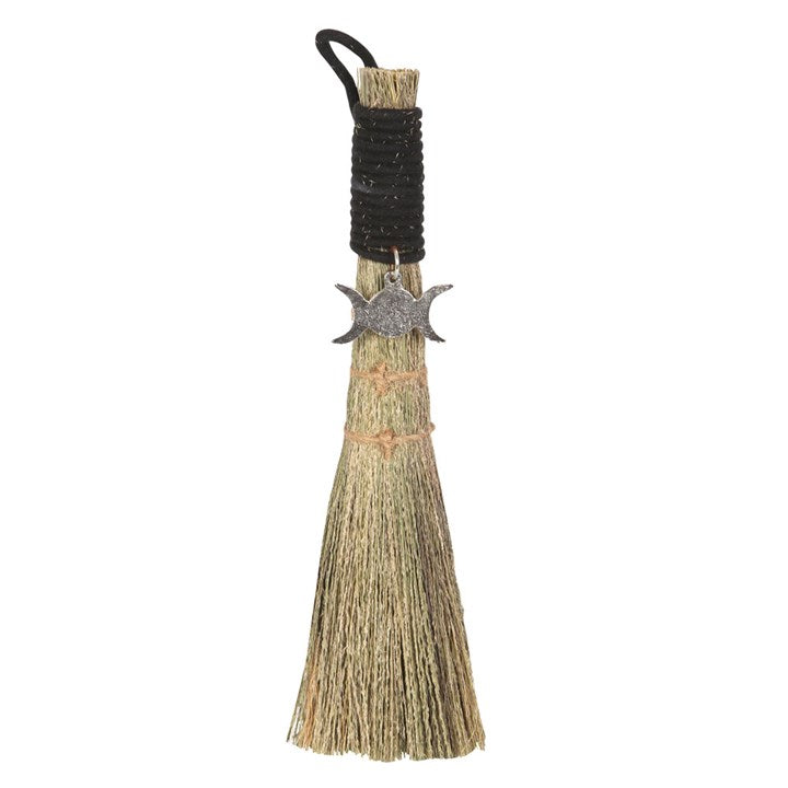 A small traditional broom with a jute string binding and a metal charm, commonly used for spiritual purposes.