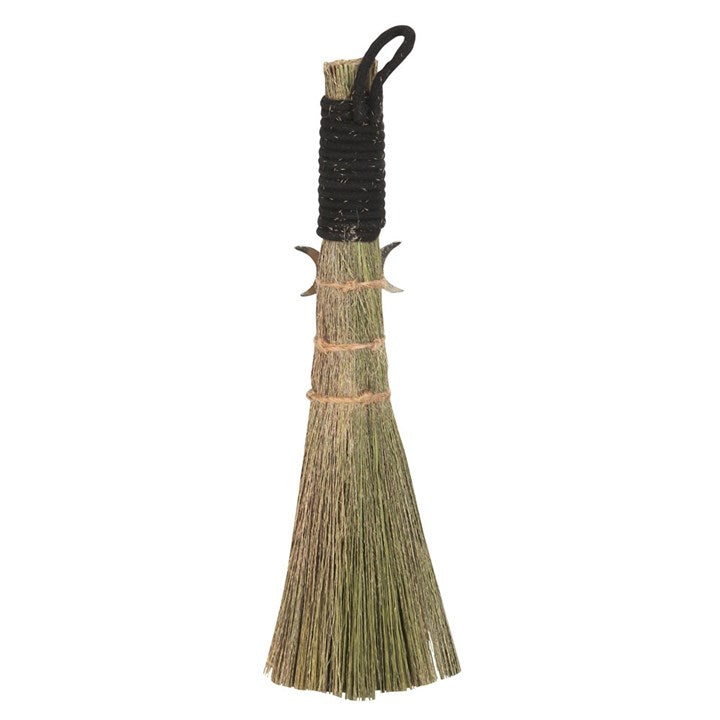 A small traditional broom with a jute string binding and a metal charm, commonly used for spiritual purposes.