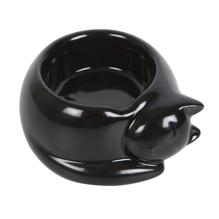A black cat-shaped tea light candle holder, placed on a white surface. 