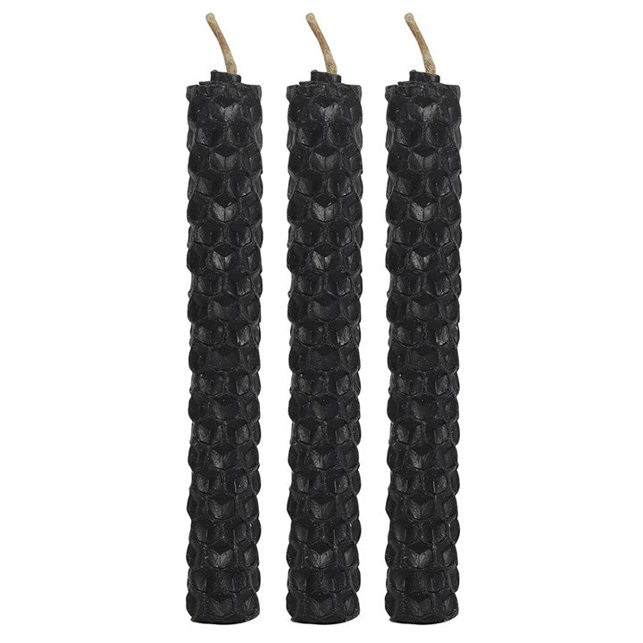 Three unlit beeswax candles stood against a white background