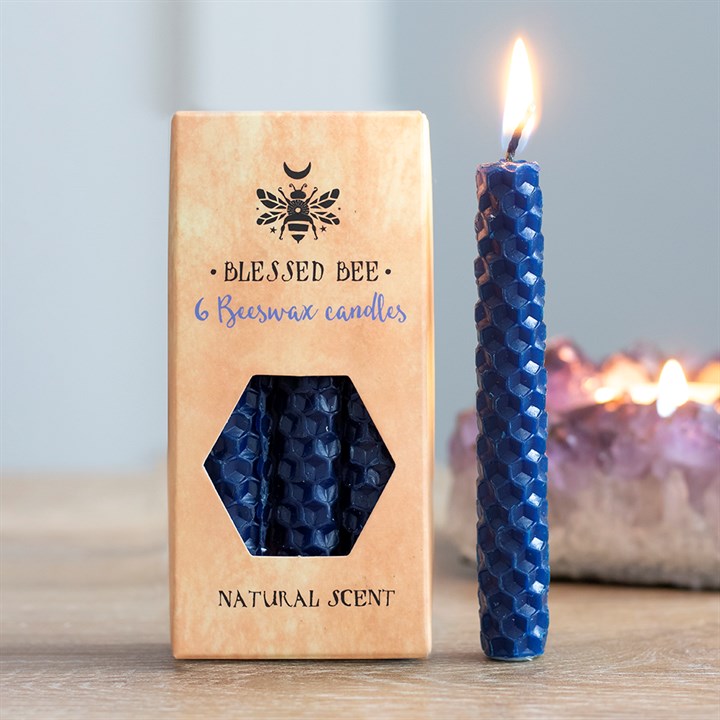 A box of blue beeswax candles displayed next to a freestanding lit blue candle