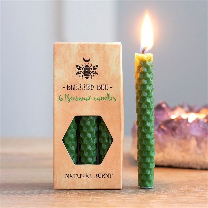 A box of green beeswax candles displayed next to a freestanding lit green candle