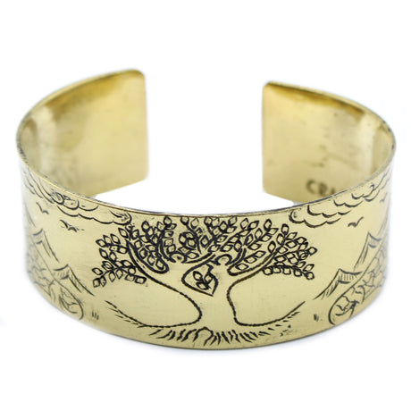 A brass Tibetan bracelet with a tree of life design on a white background