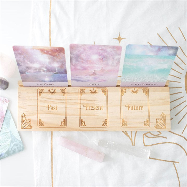 A large wooden tarot design tarot and oracle card stand with three cards, displayed on a light background.