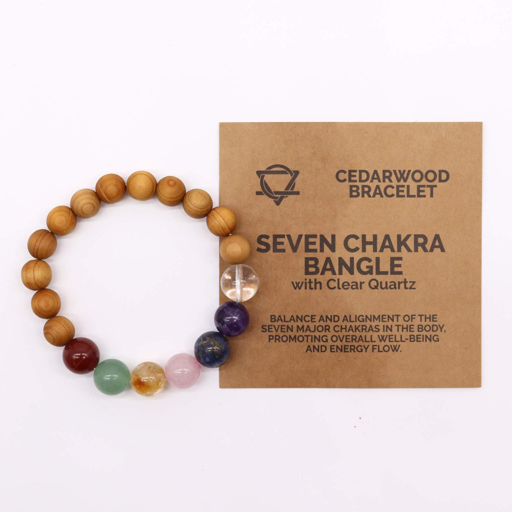 A cedarwood and crystal bead bracelet on a white background with an information sheet