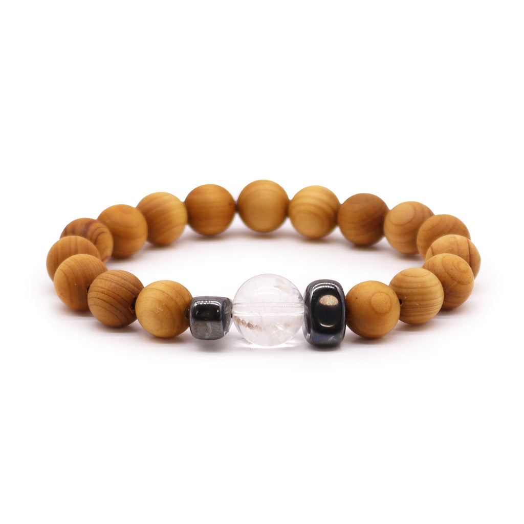A cedarwood bracelet with a clear quartz bead on a white background