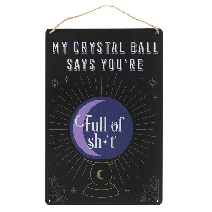 A black tin sign states "My Crystal Ball Says you're Full of Sh*t" and has a purple crystal ball with golden decor