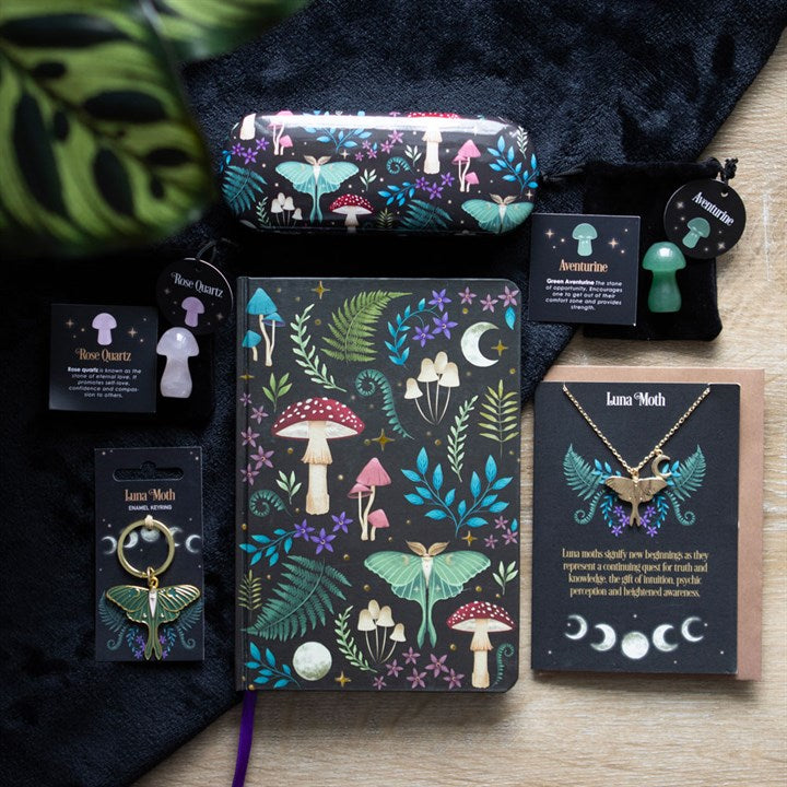 Dark Forest themed items such as mushroom, plant and lunar moth themed glasses case and notebook, lunar moth necklace and card set, lunar moth key ring and crystal mushrooms. 