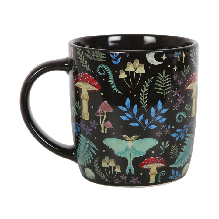 A dark forest, black ceramic mug with a colourful forest and mushroom design, displayed against a white background