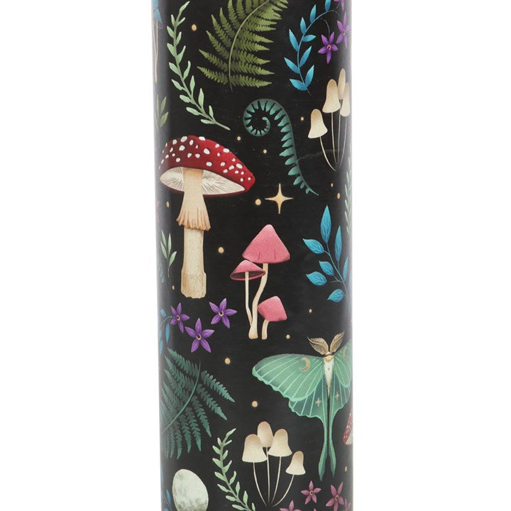 A tube candle with a label 'Wildberry Scented Candle' and an illustration of mushrooms and leaves. 
