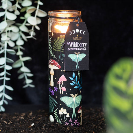 A tube candle with a label 'Wildberry Scented Candle' and an illustration of mushrooms and leaves. The candle is placed on a dark background.