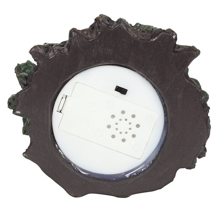 Underneath a tree shaped back flow incense burner which also lights up, showing the on/off button.