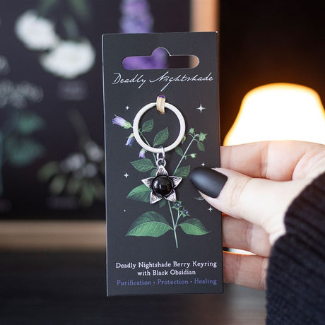 Keychain packaging with a hand holding it, featuring 'Deadly Nightshade' design.
