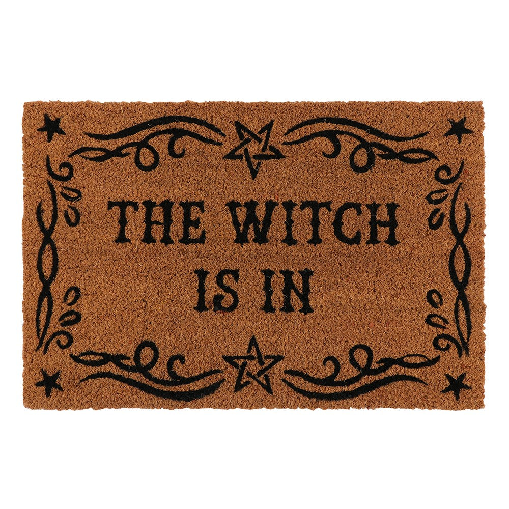 a brown "The Witch is in" doormat with black detailing 