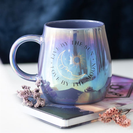 An iridescent looking mug with "live by the sun, love by the moon" design.