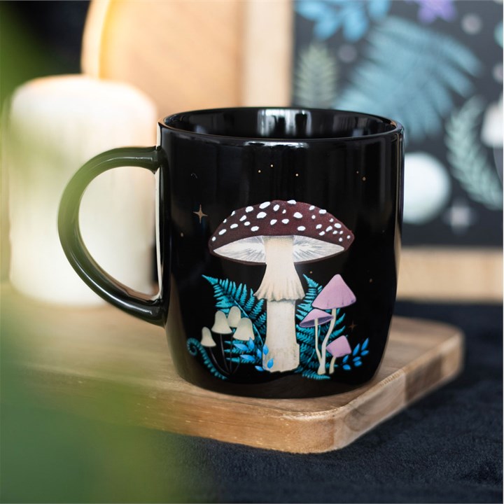 A dark forest, mushroom mug displayed on a wooden tray.