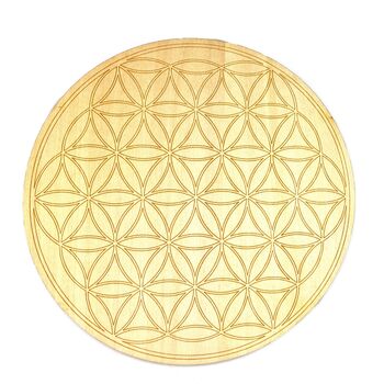 A round wooden crystal grid with the Flower of Life pattern.