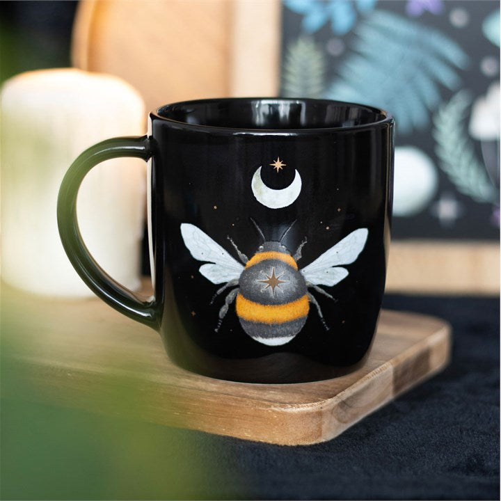 A dark forest bee mug displayed on a wooden tray.
