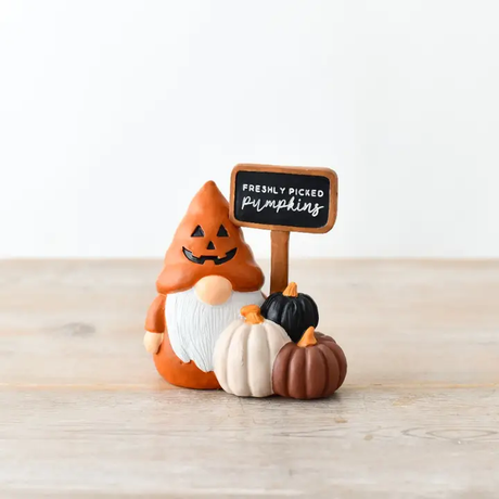 Halloween-themed gonk with pumpkins and a sign on a wooden surface