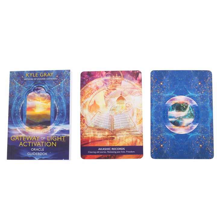 A guidebook from 'Gateway of Light Activation Oracle Cards' by Kyle Gray next to two oracle cards from the deck; one is pinks and oranges with a book stating "Akashic Records" and the second is mainly blue star themed