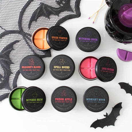 A collection of gothic-themed wax melt tins in various colours, labeled with different fragrance names such as Dragon's Blood, Spiced Pumpkin, Poison Apple, Midnight Moon, and others.