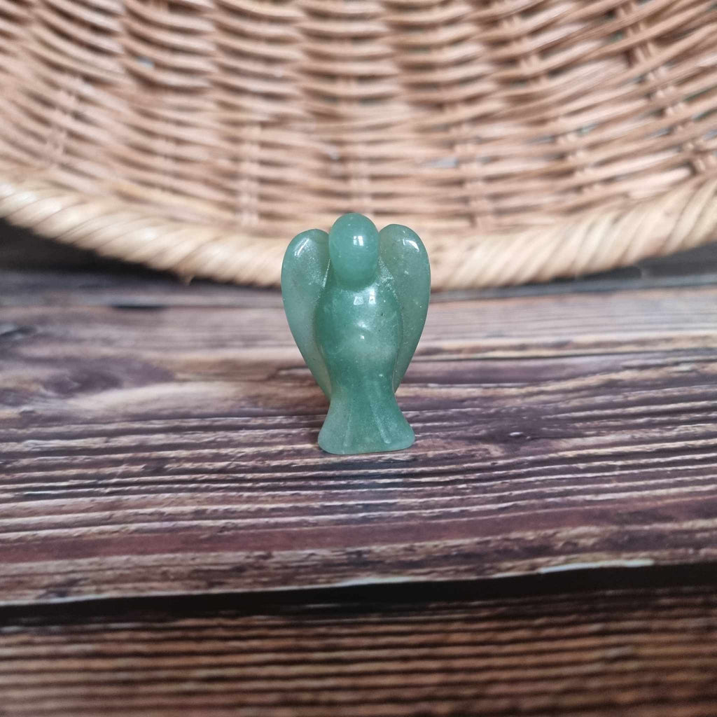 A green crystal angel on a wooden backdrop 