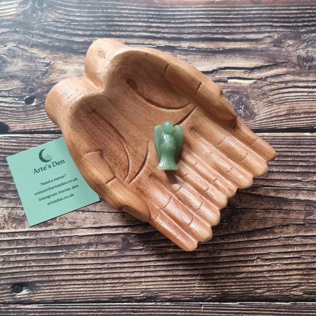 A green crystal angel on a wooden backdrop 