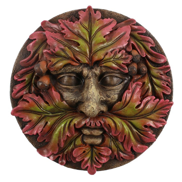A round plaque in a green man design against a white background