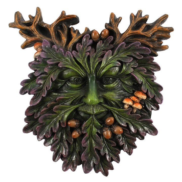 A small face-shaped plaque featuring a green man design with leaf patterns, acorns, and toadstools against a white  background
