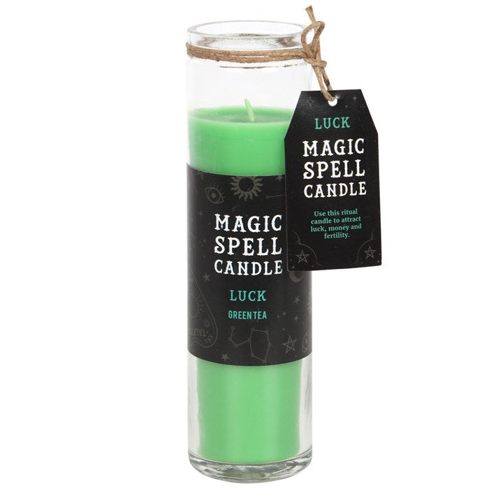 A green tube candle with a label indicating it's a Magic Spell Candle and contains Green Tea for Luck