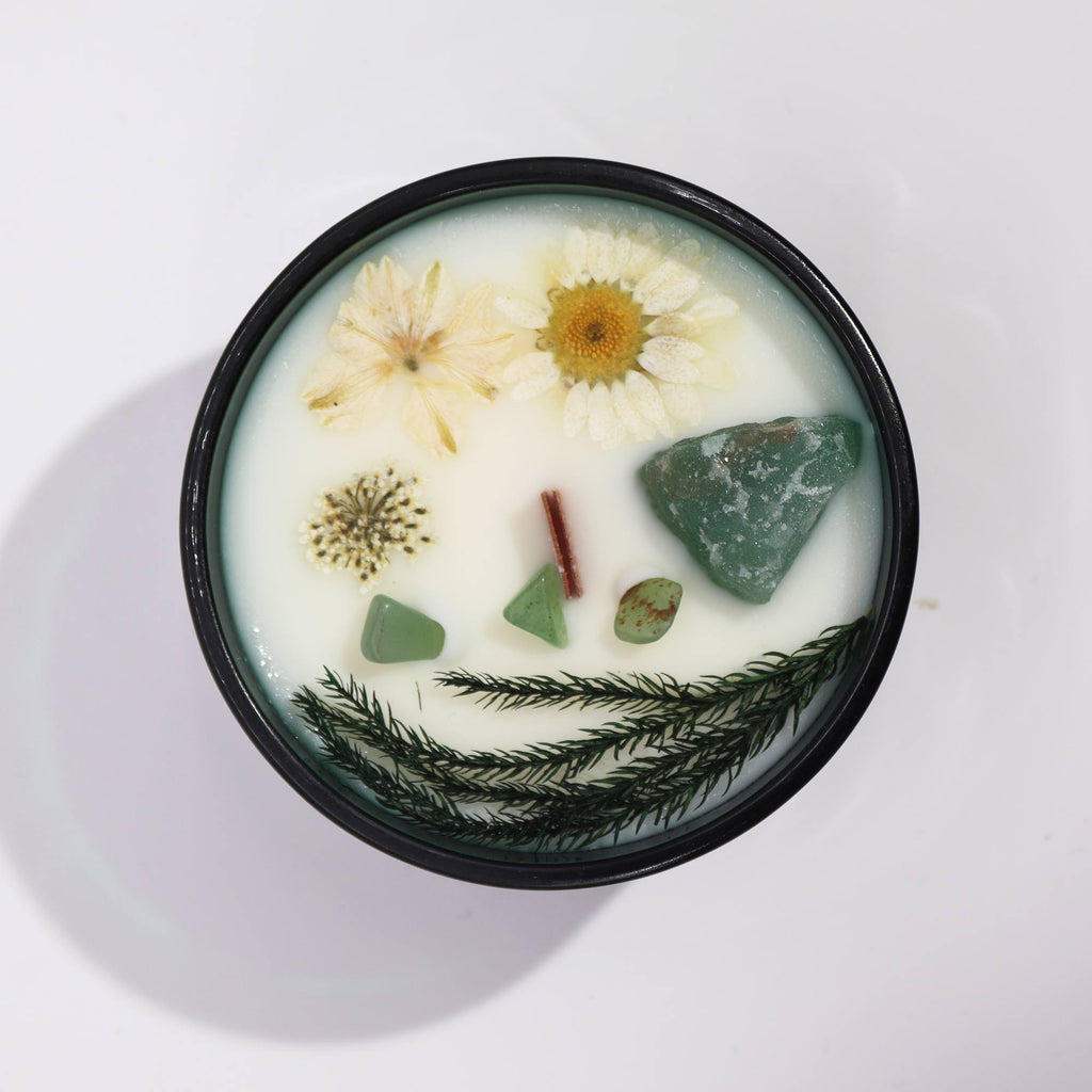 Viewed from above: A green glass crystal magic flower candle, adorned with dry flowers and jade gemstones.