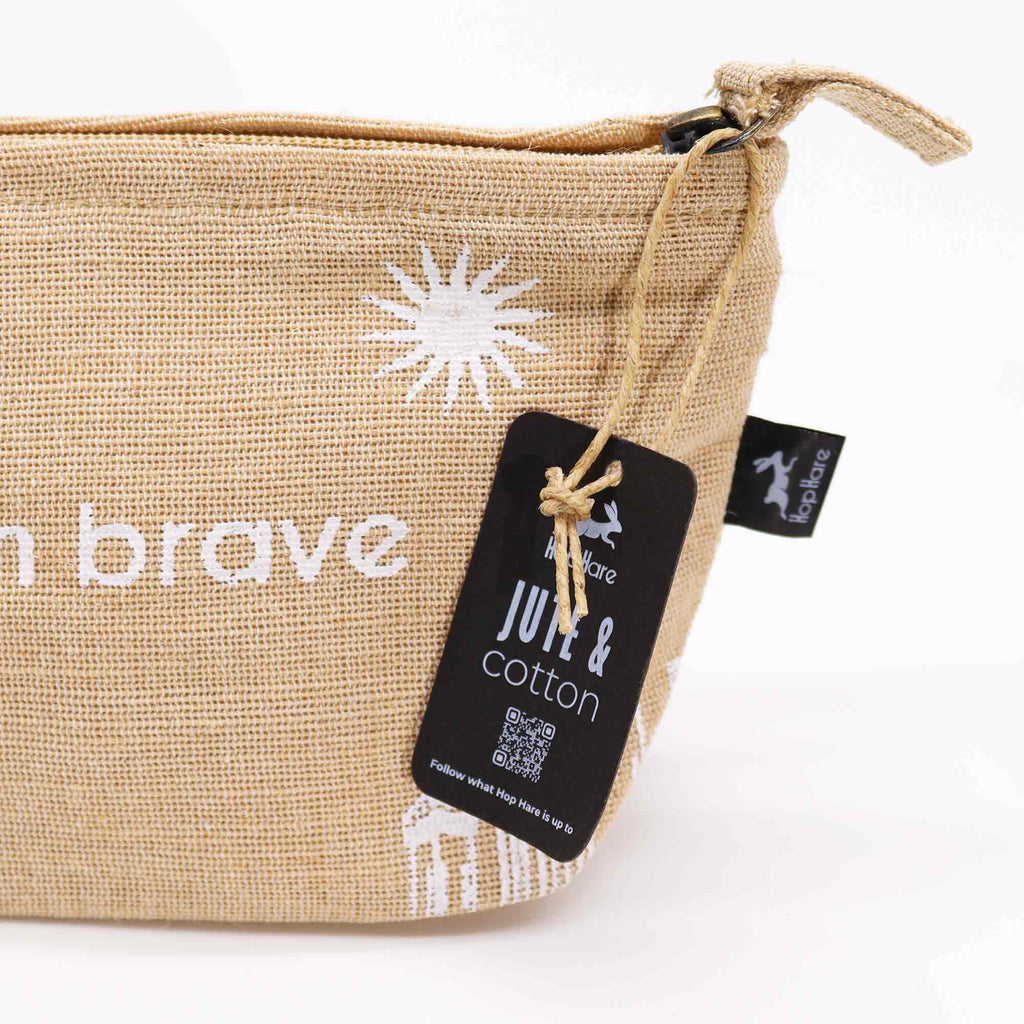 A beige jute pouch with an 'I am brave' affirmation in white. 