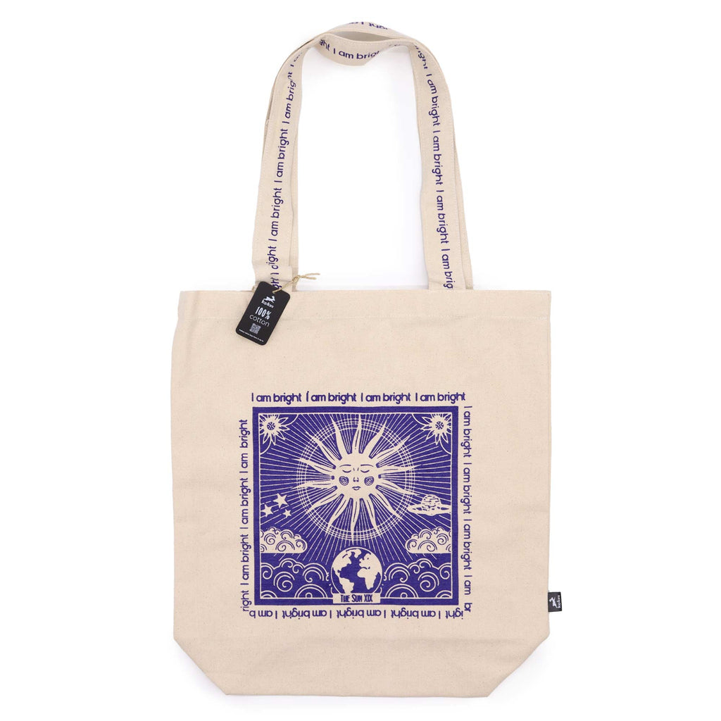 Tote bag with purple motif which is of a sun standing with the affirmation "I am bright" repeated around the motif. 
