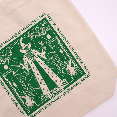 Tote bag with green motif which is of a "magician" standing in front of a castle with the affirmation "I am magical" repeated around the motif. 