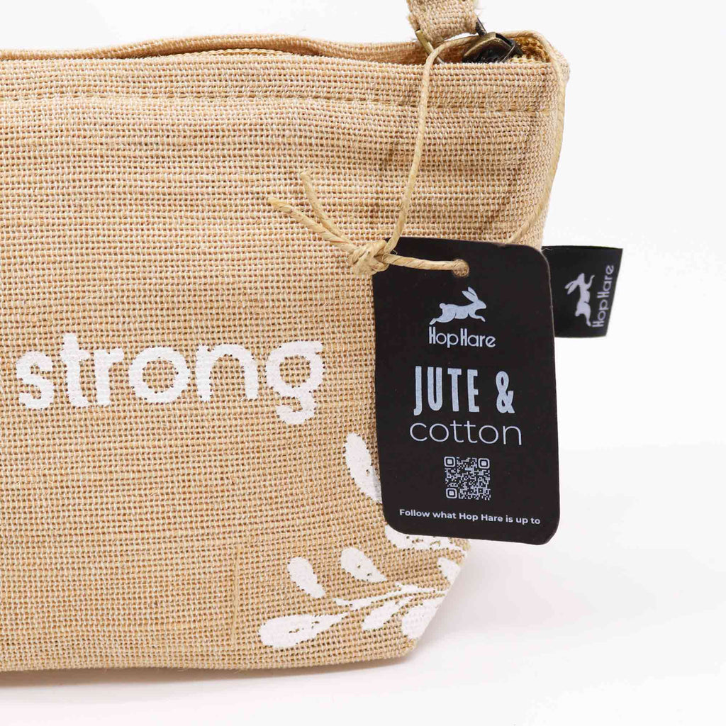 A beige jute pouch with an 'I am strong' affirmation in white. 