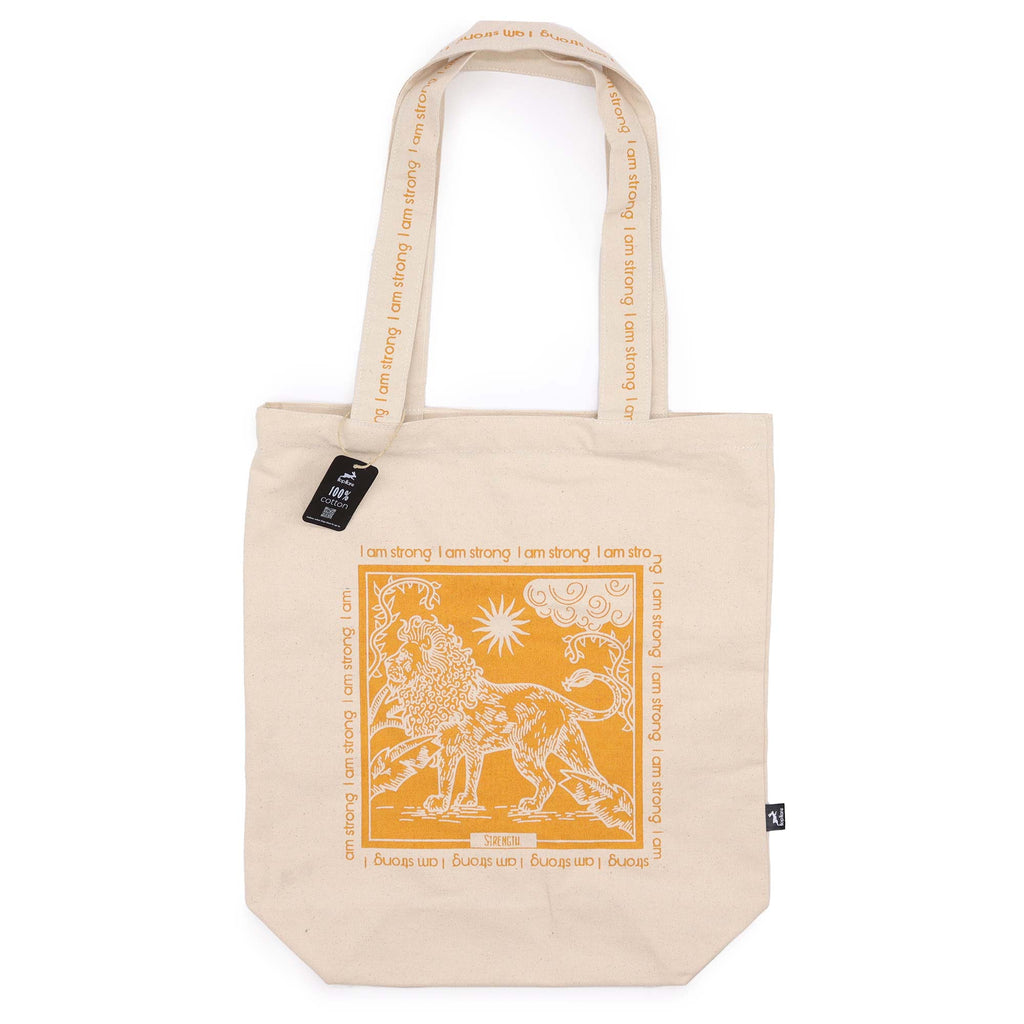 Tote bag with yellow motif which is of a lion with the affirmation "I am strong" repeated around the motif. 