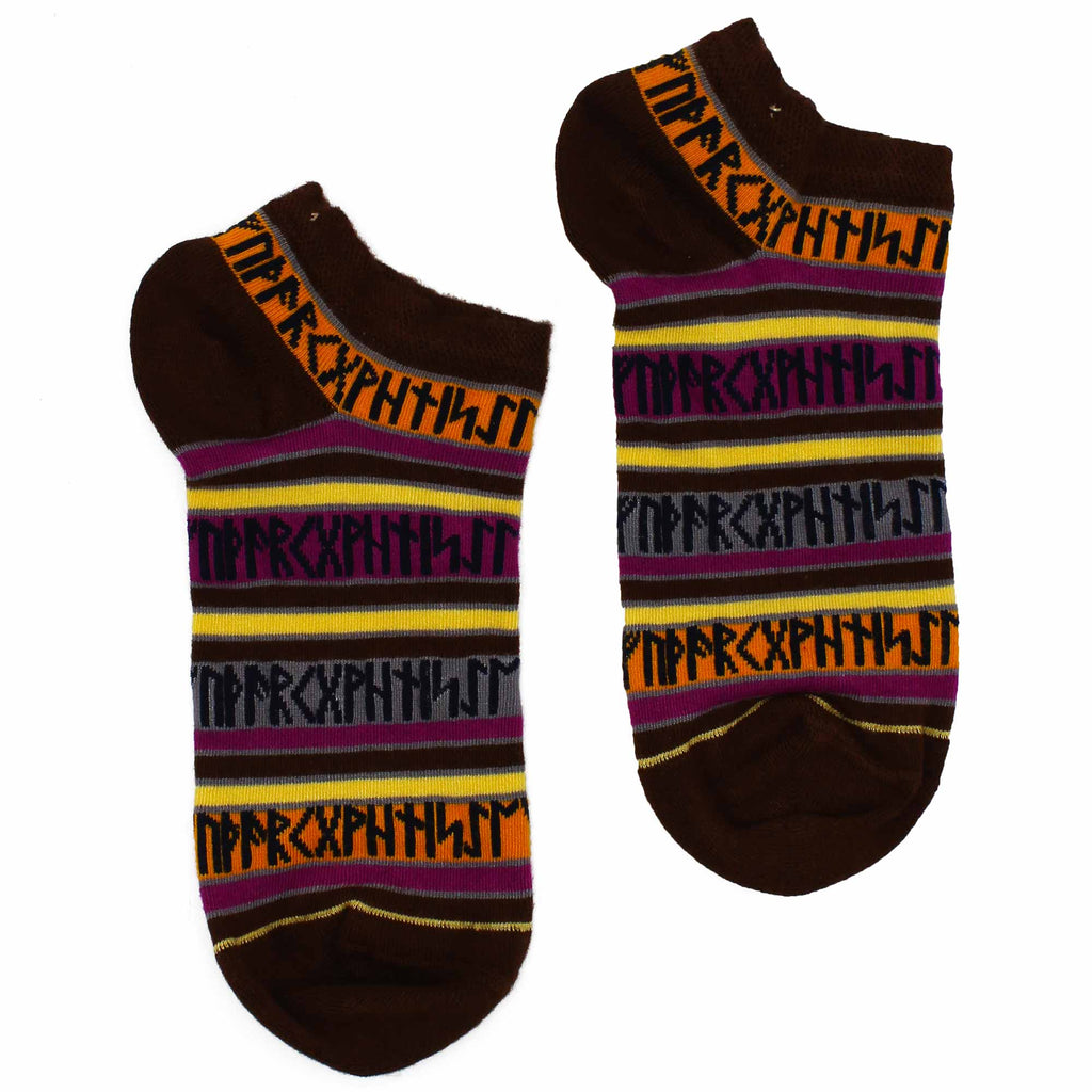 Ankle socks which are brown, with stripes of orange, pink, grey and cream with black runes, on a white surface